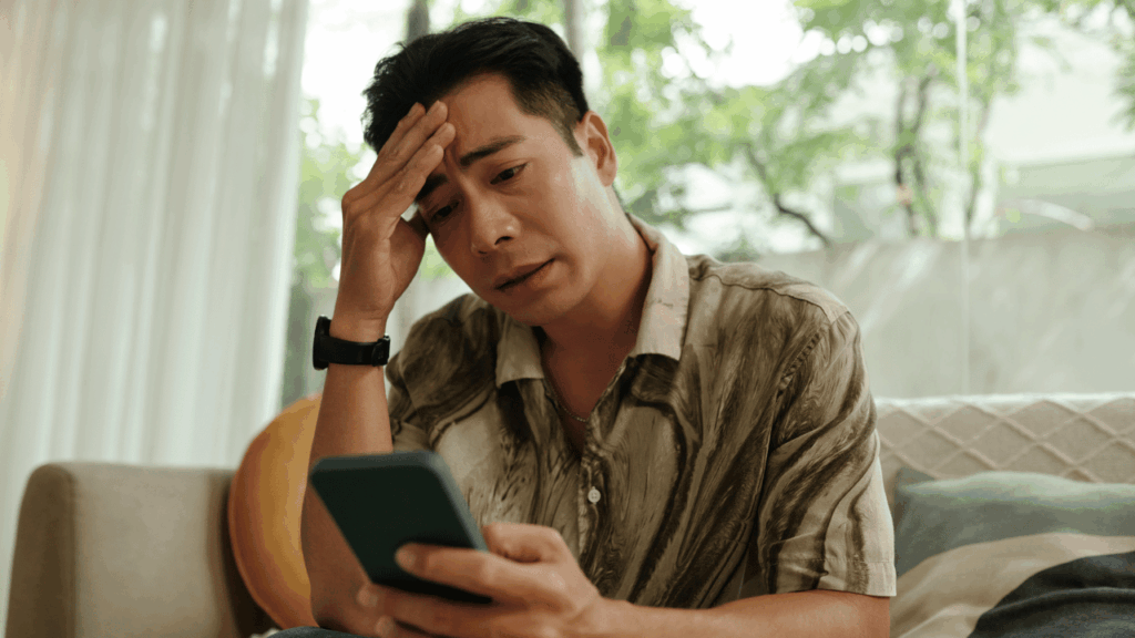 スマホを見てがっかりしてる男性